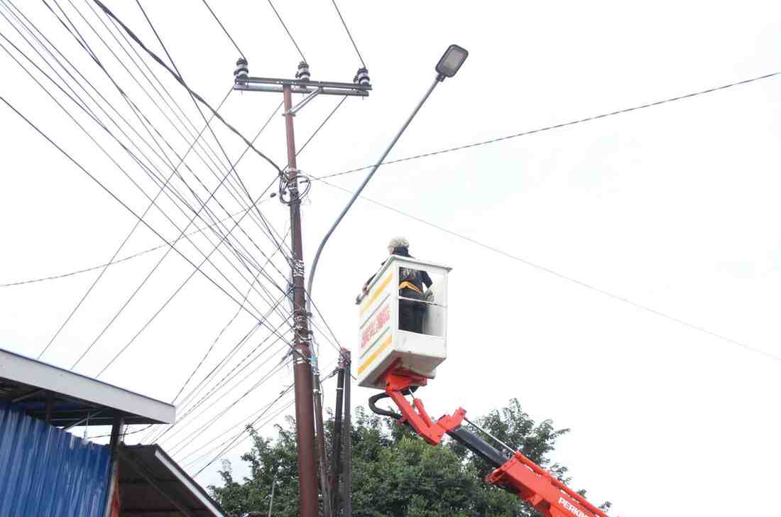 Seorang petugas edang memang lampu jalan di Gandus, Palembang, Senin (27/5/2024). Foto: Sumselheadline/Pitria.