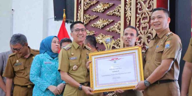 Pj Walikota Palembang, Ratu Dewa memberikan piagam penghargaan pada lurah berpretasi pada Pembinaan Aparatur Kecamatan dan Kelurahan se-Kota Palembang dan Pemberian Penghargaan Pemenang Lomba Kelurahan Tingkat Kota Palembang Tahun 2024 di Rumah Dinas Walikota, Selasa (28/5/2024). Foto: Kominfo Palembang.