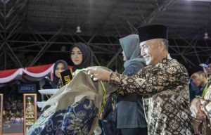 Ketua Panitia MTQ Sumsel, Ariyadi mengalungkan medali juara kepada perwakilan kafila Muba yang sukses menjadi juara umum MTQ Sumsel, Kamis (9/5/2024) malam.