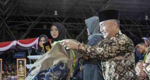 Ketua Panitia MTQ Sumsel, Ariyadi mengalungkan medali juara kepada perwakilan kafila Muba yang sukses menjadi juara umum MTQ Sumsel, Kamis (9/5/2024) malam.