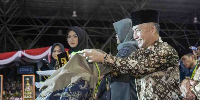 Ketua Panitia MTQ Sumsel, Ariyadi mengalungkan medali juara kepada perwakilan kafila Muba yang sukses menjadi juara umum MTQ Sumsel, Kamis (9/5/2024) malam.
