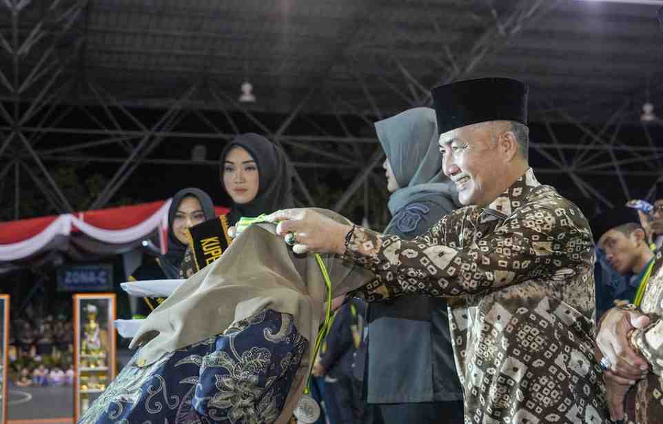 Ketua Panitia MTQ Sumsel, Ariyadi mengalungkan medali juara kepada perwakilan kafila Muba yang sukses menjadi juara umum MTQ Sumsel, Kamis (9/5/2024) malam.