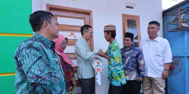 Fauzi menerima kunci rumahnya yang baru saja selesai dibedah dari Pj Walikota Palembang, Ratu Dewa, Jumat (31/5/2024). Rumahnya baru saja dibedah oleh Pemkot Palembang, Foto: Kominfo Palembang.