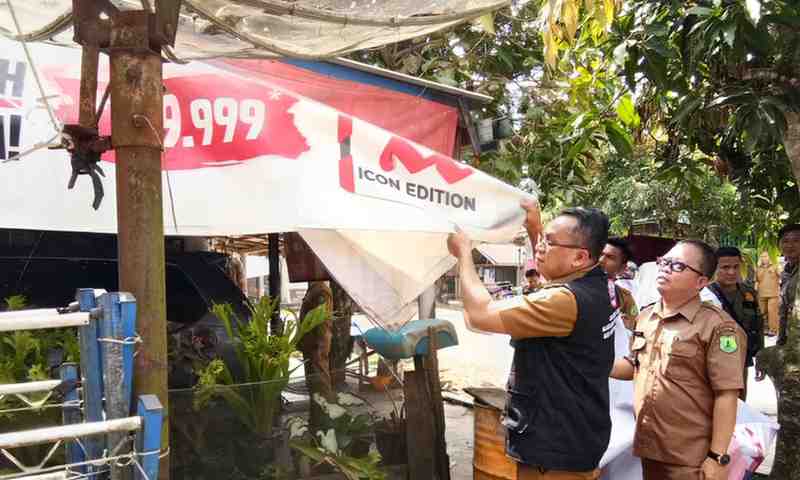 Tim petugas menurunkan spanduk tentang rokok di warung-warung di Kecamatan Sungau Keruh, Muba, demi hidup sehat, Sabtu (25/5/2024). Foto: Dok Dinkes Muba.