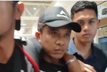 Anton, pelaku pembunuh petugas koperasi saat tiba di Bandara SMB II Palembang, Sabtu (29/6/2024). Foto: Detik sumbagsel.