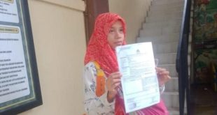 Sambil menggendong anaknya, Deliana membuat laporan ke polisi atas penganiaayaan anaknya, Kamis (6/6/2024). Foto: Sumselheadline/Ela.
