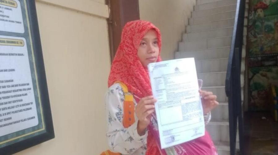 Sambil menggendong anaknya, Deliana membuat laporan ke polisi atas penganiaayaan anaknya, Kamis (6/6/2024). Foto: Sumselheadline/Ela.