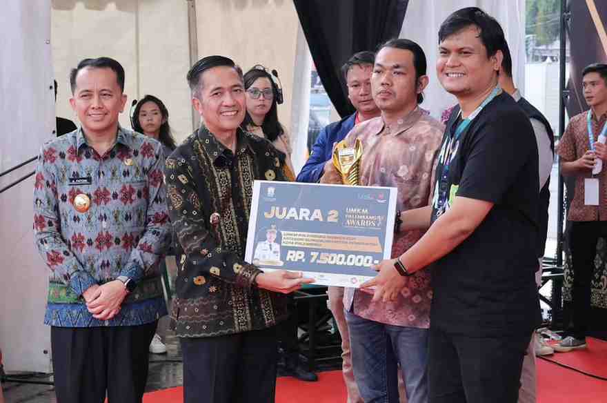 Pj Walikota Palembang, Ratu Dewa menyerahkan bantuan uang pembinaan kepada para juara UMKM terbaik di acara Puncak Penghargaan UMKM Palembang Awards 2024, Sabtu (1/6/2024). Foto: Kominfo Palembang.