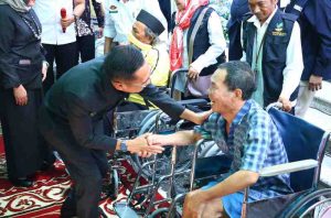 Pj Walikota Palembang, Ratu Dewa berdialog dengan seorang disabilitas, setelah memberikan bantuan kursi roda, Kamis (13/6/2024). Foto: Kominfo Palembang.