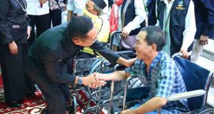 Pj Walikota Palembang, Ratu Dewa berdialog dengan seorang disabilitas, setelah memberikan bantuan kursi roda, Kamis (13/6/2024). Foto: Kominfo Palembang.