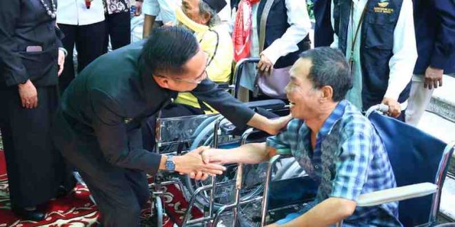 Pj Walikota Palembang, Ratu Dewa berdialog dengan seorang disabilitas, setelah memberikan bantuan kursi roda, Kamis (13/6/2024). Foto: Kominfo Palembang.
