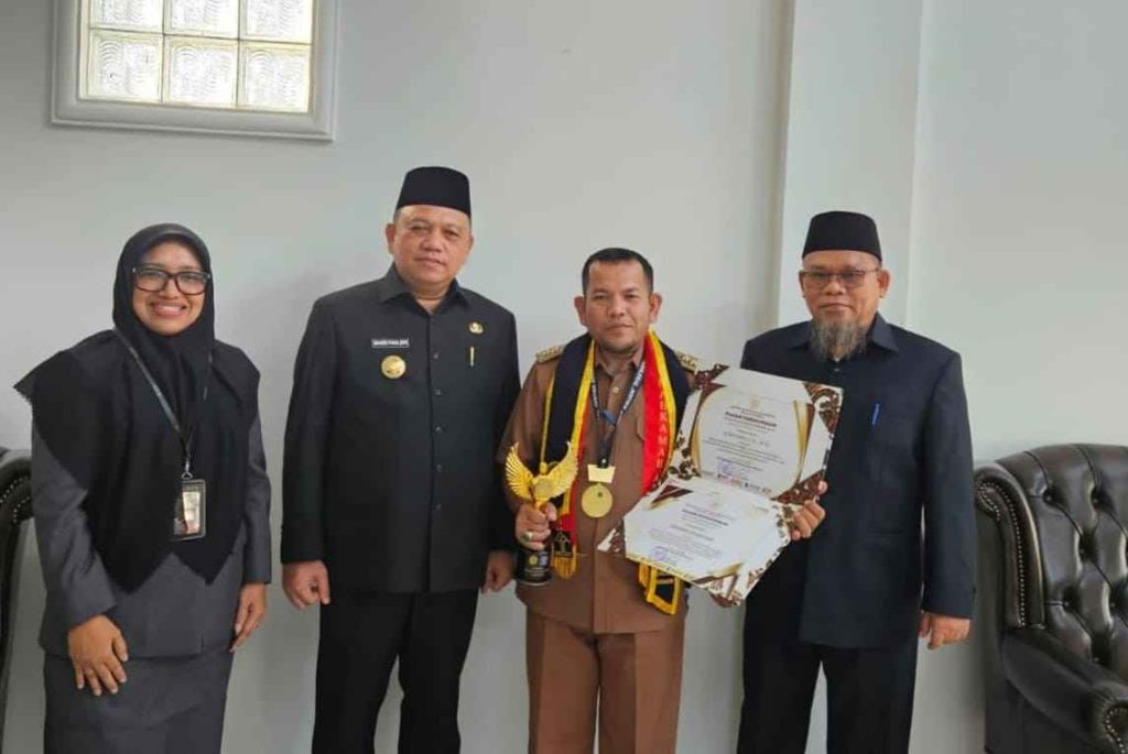 Periyanto, Lurah Serasan Jaya bersama Pj Bupati Muba, Sandi Fahlevi usai menerima penghargaan paralegal. Foto: Kominfo Muba.