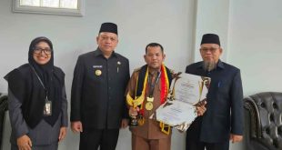 Periyanto, Lurah Serasan Jaya bersama Pj Bupati Muba, Sandi Fahlevi usai menerima penghargaan paralegal. Foto: Kominfo Muba.