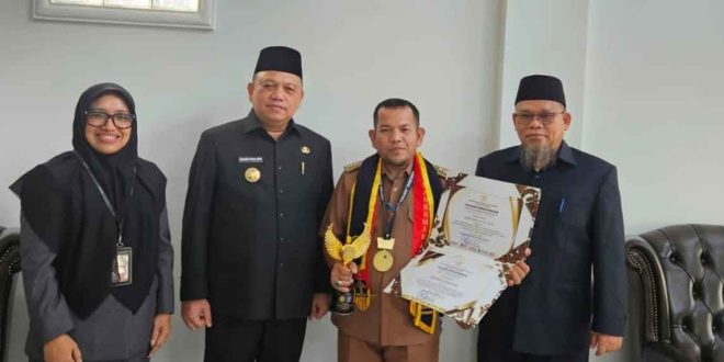 Periyanto, Lurah Serasan Jaya bersama Pj Bupati Muba, Sandi Fahlevi usai menerima penghargaan paralegal. Foto: Kominfo Muba.