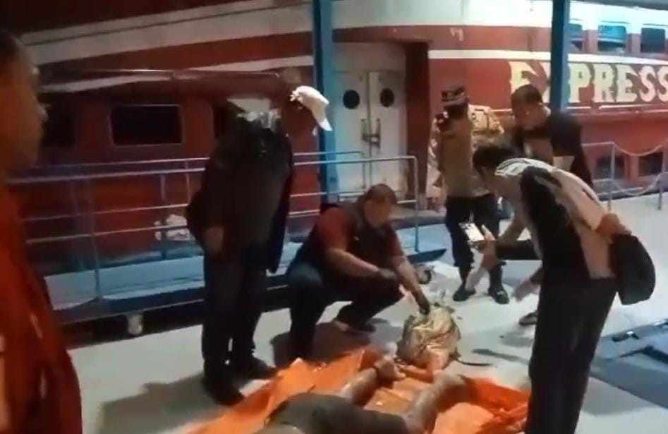 Polisi dan warga mengevakuasi mayat yang ditemukan terikat rantai besi di Sungai Musi, Rabu (19/6/2024). Foto: Sumselheadline/Ela.