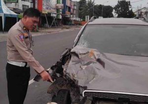 Seorang Polantas menunjukkan bagian mobil Chevrolet Captiva BG 1340AH yang menabrak pengendara motor, Selasa (4/6/2024). Foto: Sumselheadlline/Ela.