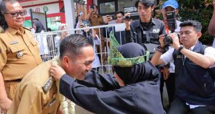Pj Walikota Palembang, Ratu Dewa dikalungkan bunga oleh siswa saat tiba di SDN 84 Palembang, Selasa (11/6/2024). Foto: Kominfo Palembang.
