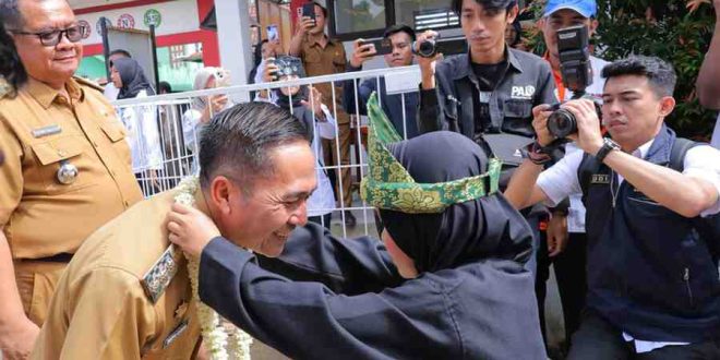 Pj Walikota Palembang, Ratu Dewa dikalungkan bunga oleh siswa saat tiba di SDN 84 Palembang, Selasa (11/6/2024). Foto: Kominfo Palembang.