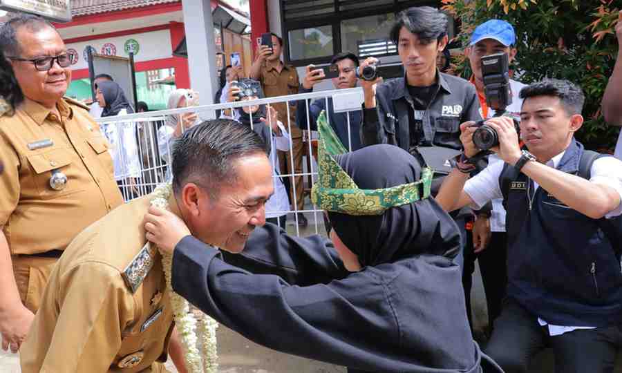 Pj Walikota Palembang, Ratu Dewa dikalungkan bunga oleh siswa saat tiba di SDN 84 Palembang, Selasa (11/6/2024). Foto: Kominfo Palembang.