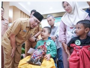 Sekda Muba, Apriyadi bercengkerama dengan anak yang ikut sunatan massal di Sekayu, Selasa (25/6/2024). Foto: Kominfo Muba.