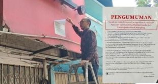 Petugas pemilik ruko melepas stiker yang ditempeli seseorang, yang berisi pernyataan bahwa bangunan itu milik ahli waris, Jumat (26/7/2024). Foto: Sumselheadline/Ela.