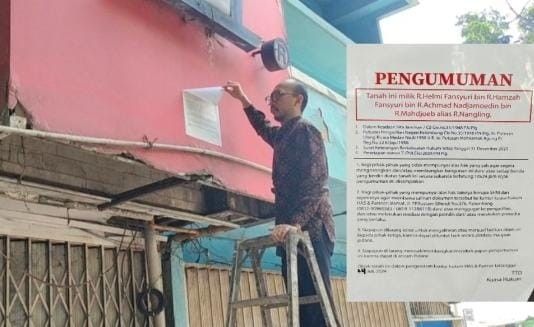 Petugas pemilik ruko melepas stiker yang ditempeli seseorang, yang berisi pernyataan bahwa bangunan itu milik ahli waris, Jumat (26/7/2024). Foto: Sumselheadline/Ela.