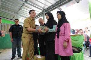 Sekda Palembang, Ratu Dewa memberikan bantuan kepada keluarga penyandang tuna netra Palembang, Selasa (2/7/2024). Foto: Sumselheadline/Pitria.