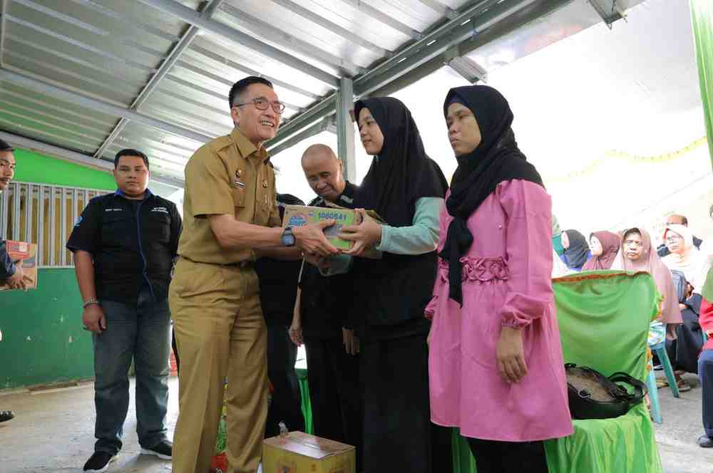 Sekda Palembang, Ratu Dewa memberikan bantuan kepada keluarga penyandang tuna netra Palembang, Selasa (2/7/2024). Foto: Sumselheadline/Pitria.