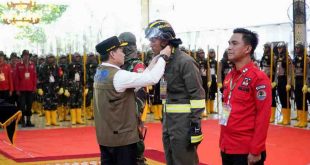 Pj Gubernur Sumsel, Elen Setiadi secara simbolis memasang pakaian kerja tim seiaga Karhutlah yang mengikuti pelatihan di Griya Agung, Kamis (25/7/2024). Foto: Humas Pemprov Sumsel.