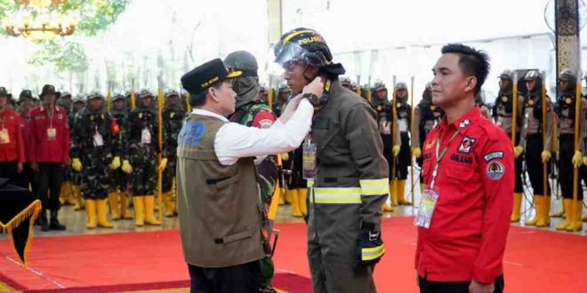 Pj Gubernur Sumsel, Elen Setiadi secara simbolis memasang pakaian kerja tim seiaga Karhutlah yang mengikuti pelatihan di Griya Agung, Kamis (25/7/2024). Foto: Humas Pemprov Sumsel.