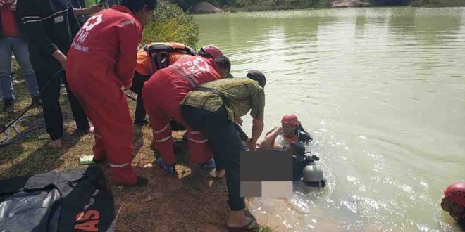 Sejumlah petugas yang tengah mengevakuasi bocah yang tenggelam di bekas galian, dekat Asrama Haji Palembang, Sabtu (27/7/2024). Foto: Dok Basarnas Palembang.