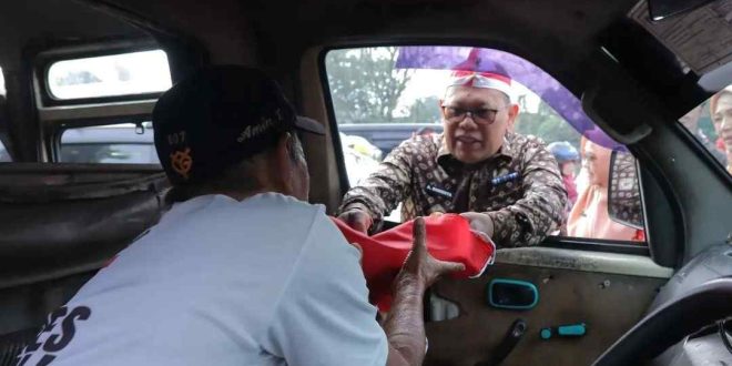 Pj Walikota Palembang, A Damenta ikut membagikan scara gratis bendera m,erah putih, Kamis (15/8/2024) . Foto: Sumselheadline/Pitria.