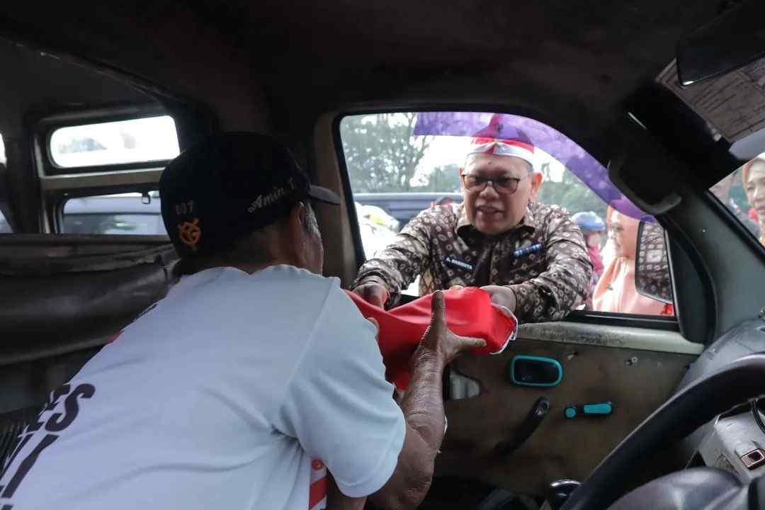 Pj Walikota Palembang, A Damenta ikut membagikan scara gratis bendera m,erah putih, Kamis (15/8/2024) . Foto: Sumselheadline/Pitria.