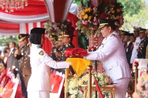 PJ Gubernur Sumsel, Elen Setiadi menyerahkan bendera kepada pengerek bendera upacara HUT Kemerdekaan RI ke-79, Sabtu (17/8/2024). Foto: Humas Pemprov Sumsel.
