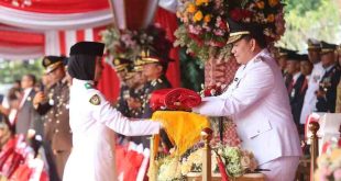 PJ Gubernur Sumsel, Elen Setiadi menyerahkan bendera kepada pengerek bendera upacara HUT Kemerdekaan RI ke-79, Sabtu (17/8/2024). Foto: Humas Pemprov Sumsel.