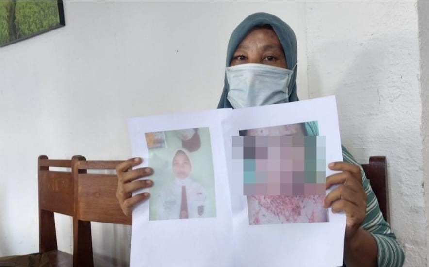 Ibu korban menunjukkan foto anaknya yang diduga menjadi korban malapraktek oknum bidan. Foto: Dok Sumselheadline.