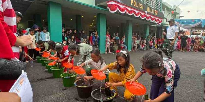 Anak-anak antusias ikut lomba memasukkan air dalam botol di halaman subdenpom, Sekayu, Minggu (188/2024). Foto: Kominfo Muba.