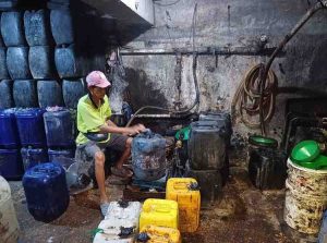 Seorang pekerja sedang memasukkan minyak curah ke jerigen di tangki baseman Pasar 16 Ilir Palembang, Selasa (6/8/2024). Foto: Sumselheadline/Pitria.