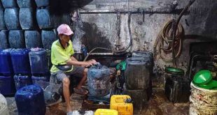 Seorang pekerja sedang memasukkan minyak curah ke jerigen di tangki baseman Pasar 16 Ilir Palembang, Selasa (6/8/2024). Foto: Sumselheadline/Pitria.