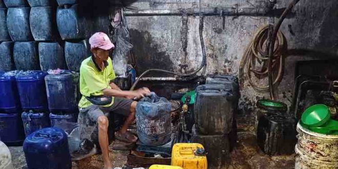 Seorang pekerja sedang memasukkan minyak curah ke jerigen di tangki baseman Pasar 16 Ilir Palembang, Selasa (6/8/2024). Foto: Sumselheadline/Pitria.