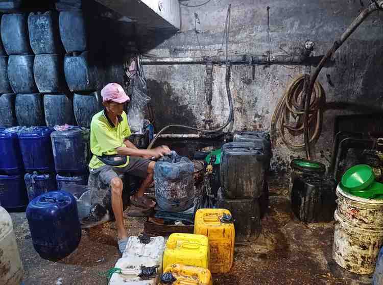 Seorang pekerja sedang memasukkan minyak curah ke jerigen di tangki baseman Pasar 16 Ilir Palembang, Selasa (6/8/2024). Foto: Sumselheadline/Pitria.