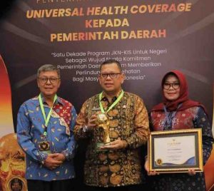 Pj Walikota Palembang, A Damenta menerima piala UHC Award dari pemerintah pusat, Kamis (8/9/2024) malam. Foto: Kominfo Palembang.