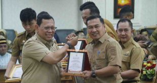 Pj Walikota Palembang, A Damenta memberikan pelakat penghargaan kepada Kadis Kominfo, Adi Zahri, Senin (2/9/2024). Foto: Kominfo Palembang.