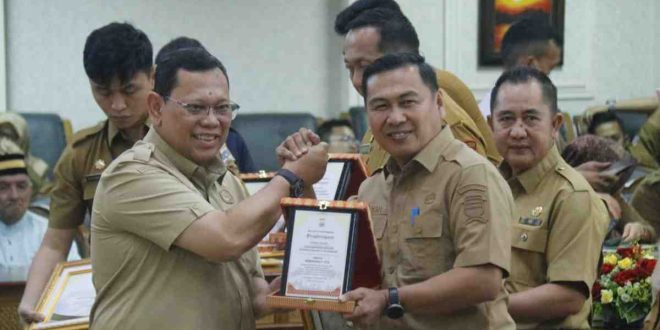 Pj Walikota Palembang, A Damenta memberikan pelakat penghargaan kepada Kadis Kominfo, Adi Zahri, Senin (2/9/2024). Foto: Kominfo Palembang.