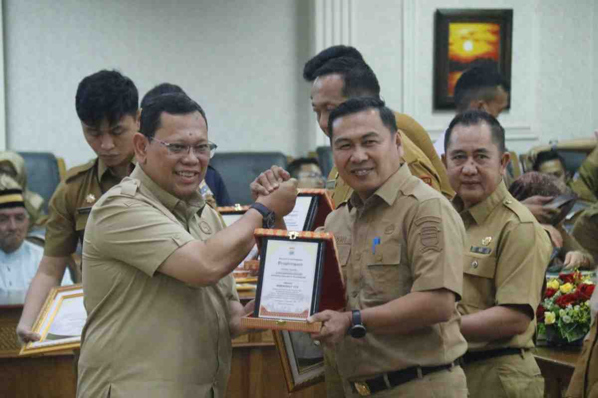Pj Walikota Palembang, A Damenta memberikan pelakat penghargaan kepada Kadis Kominfo, Adi Zahri, Senin (2/9/2024). Foto: Kominfo Palembang.