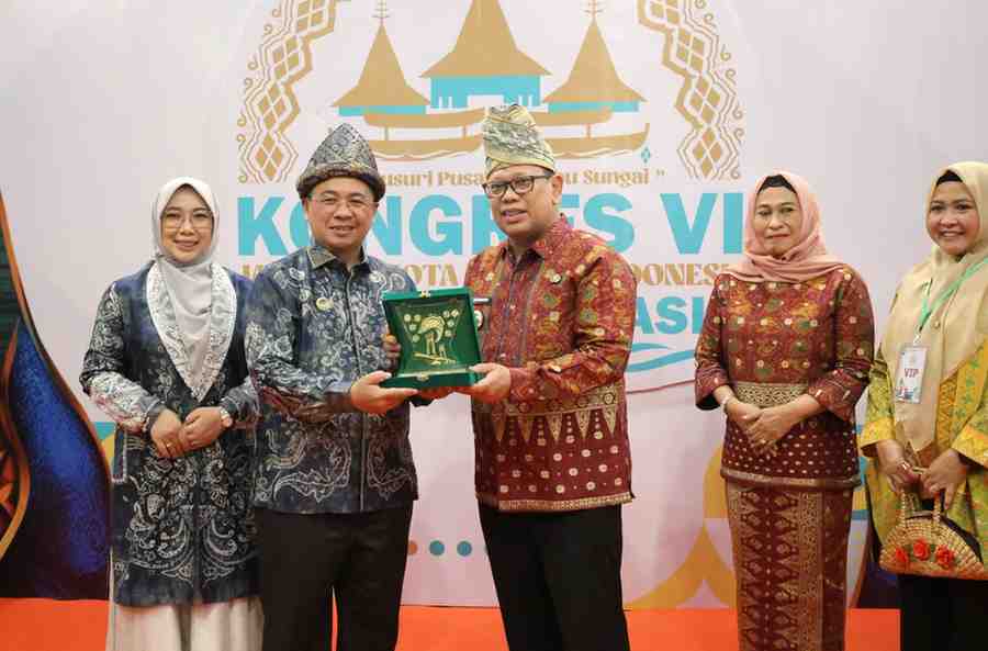 Pj Walikota Palembang Ucok Abdulrauf Damenta bertukar cendera mata dengan WalikKota Banjarmasin Ibnu Sina. Foto: Kominfo Palembang.