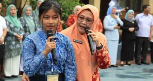 Ketua Dharma Wanita Persatuan (DWP) Kota Palembang, Ida Riyani Aprizal bersama seorang siswa saat menggelar goes to scholl di SMPN 1 Palembang, Rabu (25/9/2024). Foto: Kominfo Palembang.