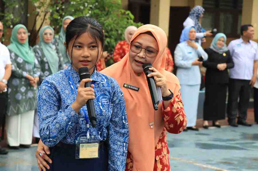 Ketua Dharma Wanita Persatuan (DWP) Kota Palembang, Ida Riyani Aprizal bersama seorang siswa saat menggelar goes to scholl di SMPN 1 Palembang, Rabu (25/9/2024). Foto: Kominfo Palembang.