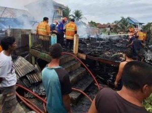 Warga dan petugas memadamkan sisa api yang melahap dua rumah di 35 Ilir Palembang, Senin (2/12/2024). Foto: Sumselheadline/Ela.