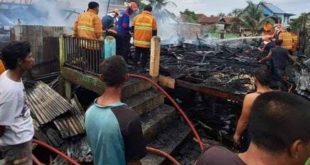 Warga dan petugas memadamkan sisa api yang melahap dua rumah di 35 Ilir Palembang, Senin (2/12/2024). Foto: Sumselheadline/Ela.